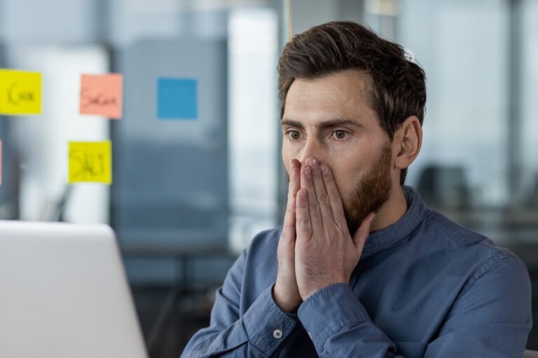 Mann erschrocken am Laptop