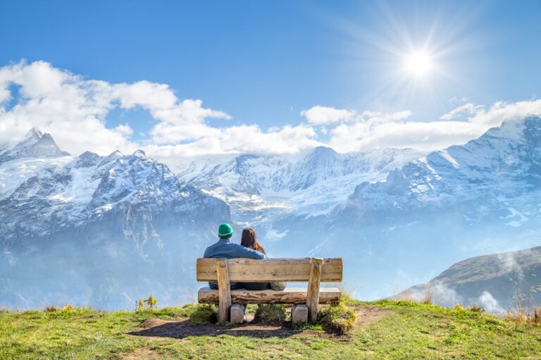 Glückliches Paar auf einer Bank in den Alpen