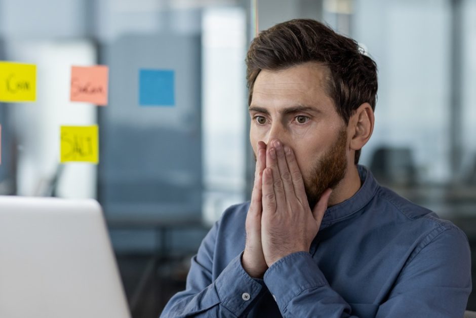 Mann erschrocken am Laptop